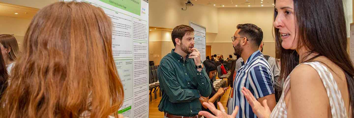 students and faculty in discussion at sciences poster session